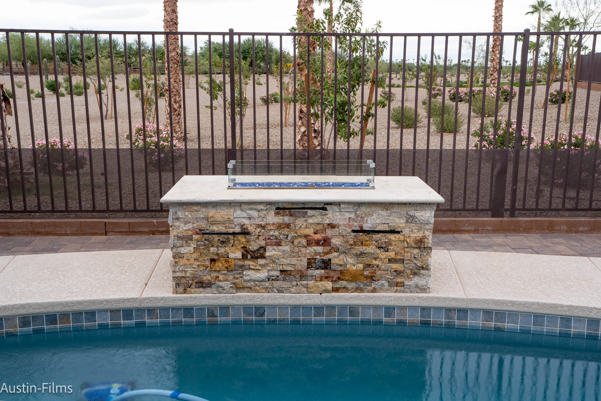 Stone fire feature beside a backyard swimming pool