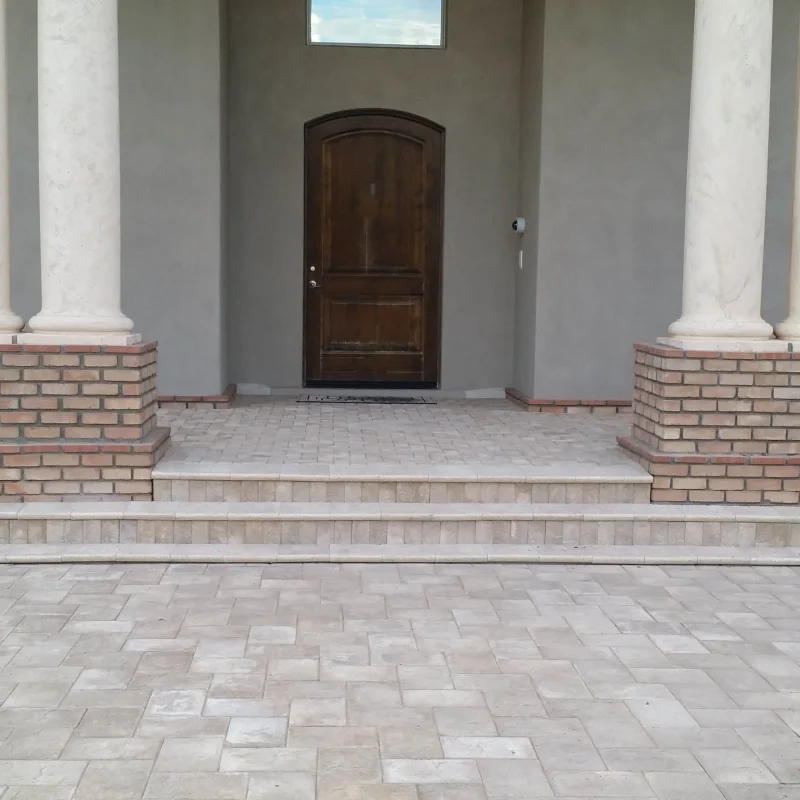 Front porch with columns, steps, and arched wooden door