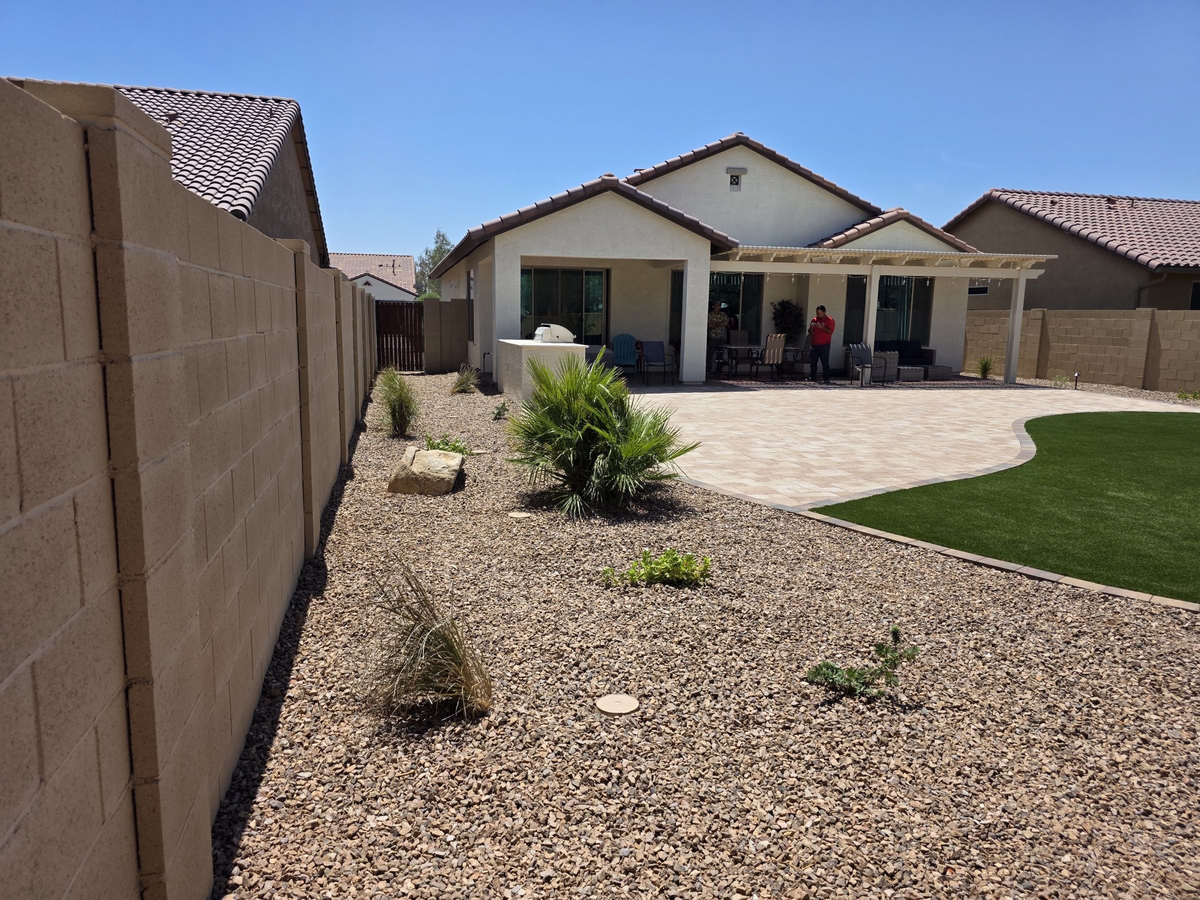 Landscaped backyard patio with pergola and artificial turf