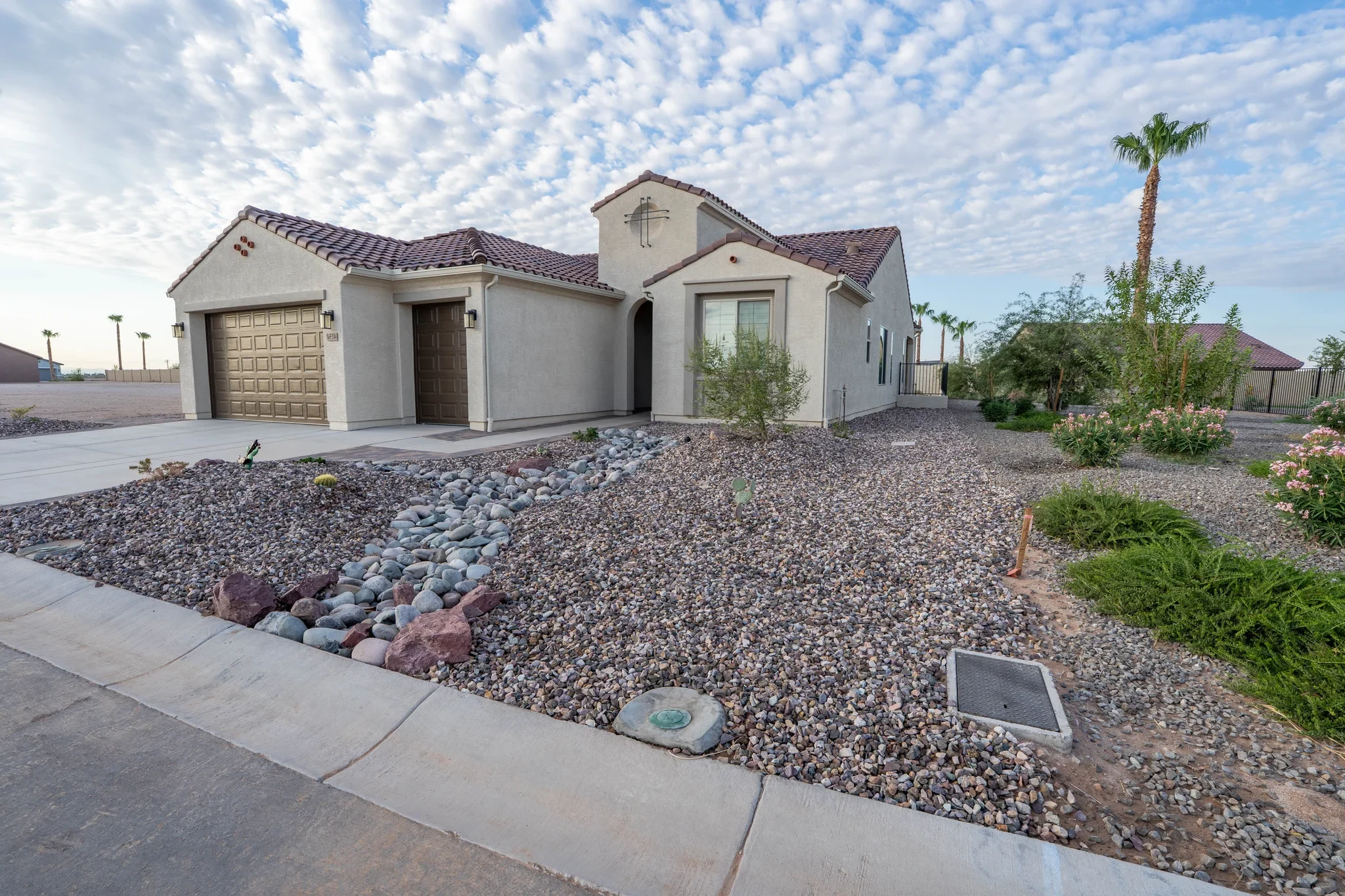 Desert-style stucco home with tiled roof and two-car garage