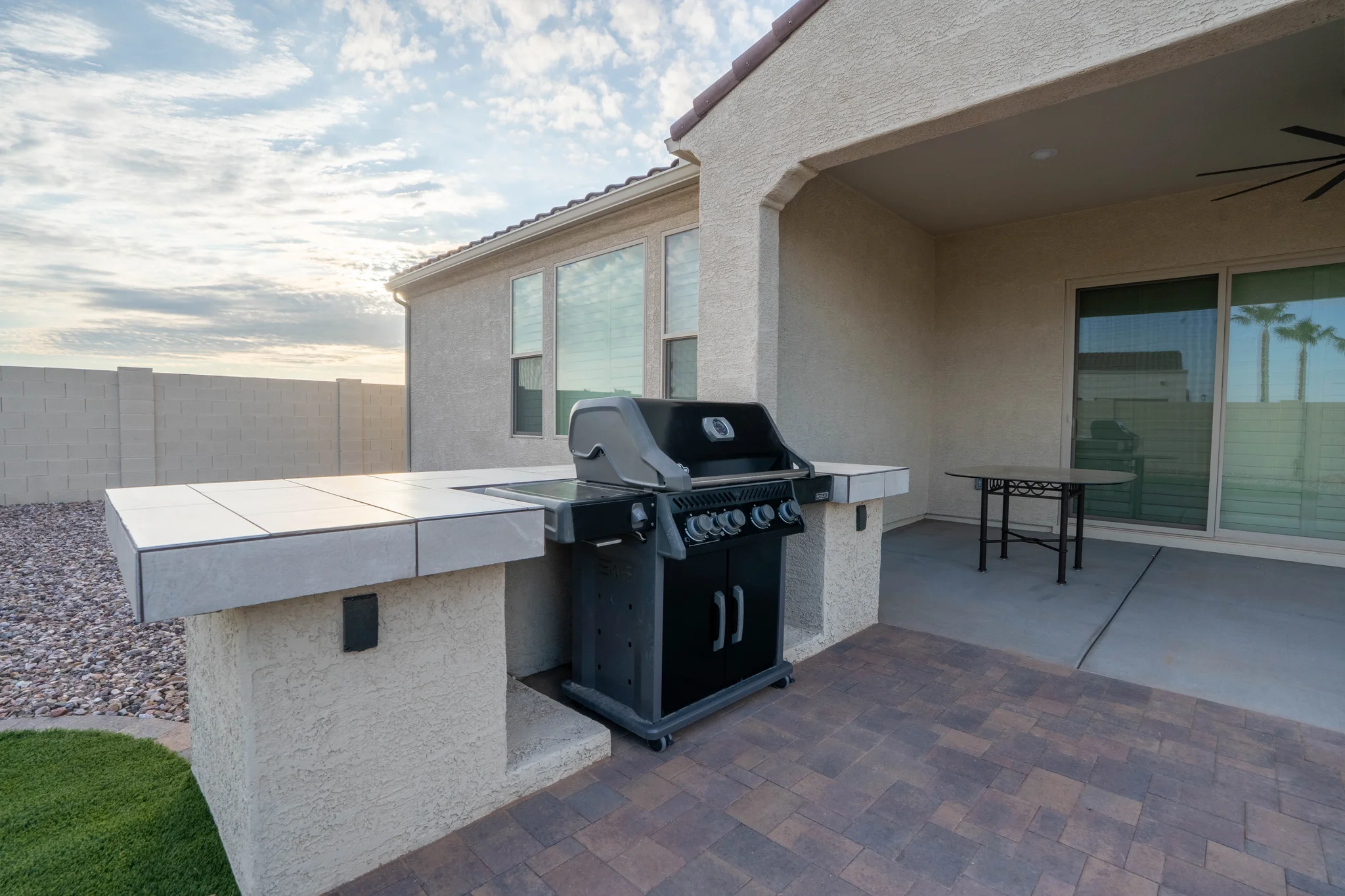 Covered patio with gas grill and tiled outdoor counter