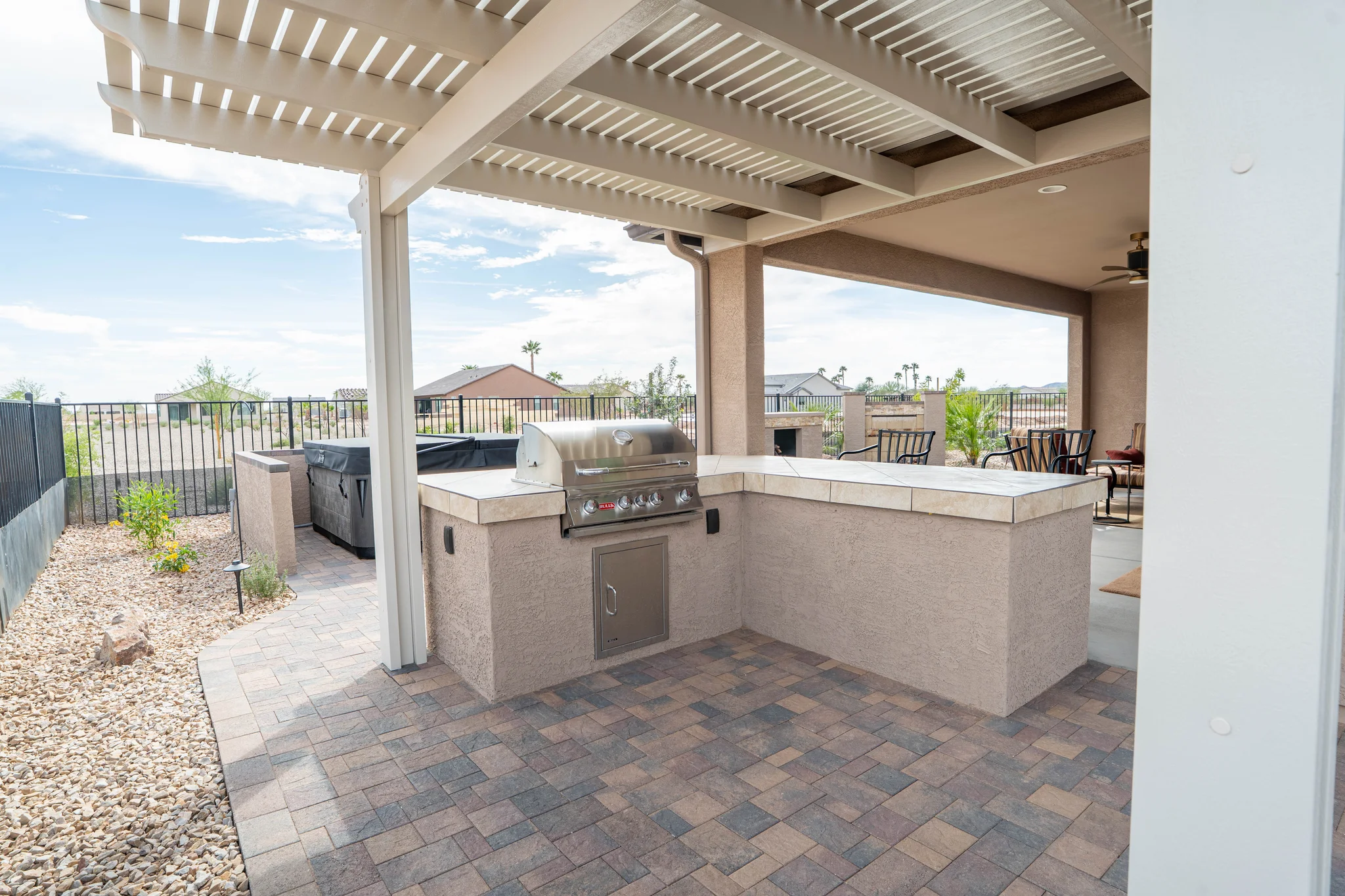 Covered patio kitchen with grill, bar, and pergola