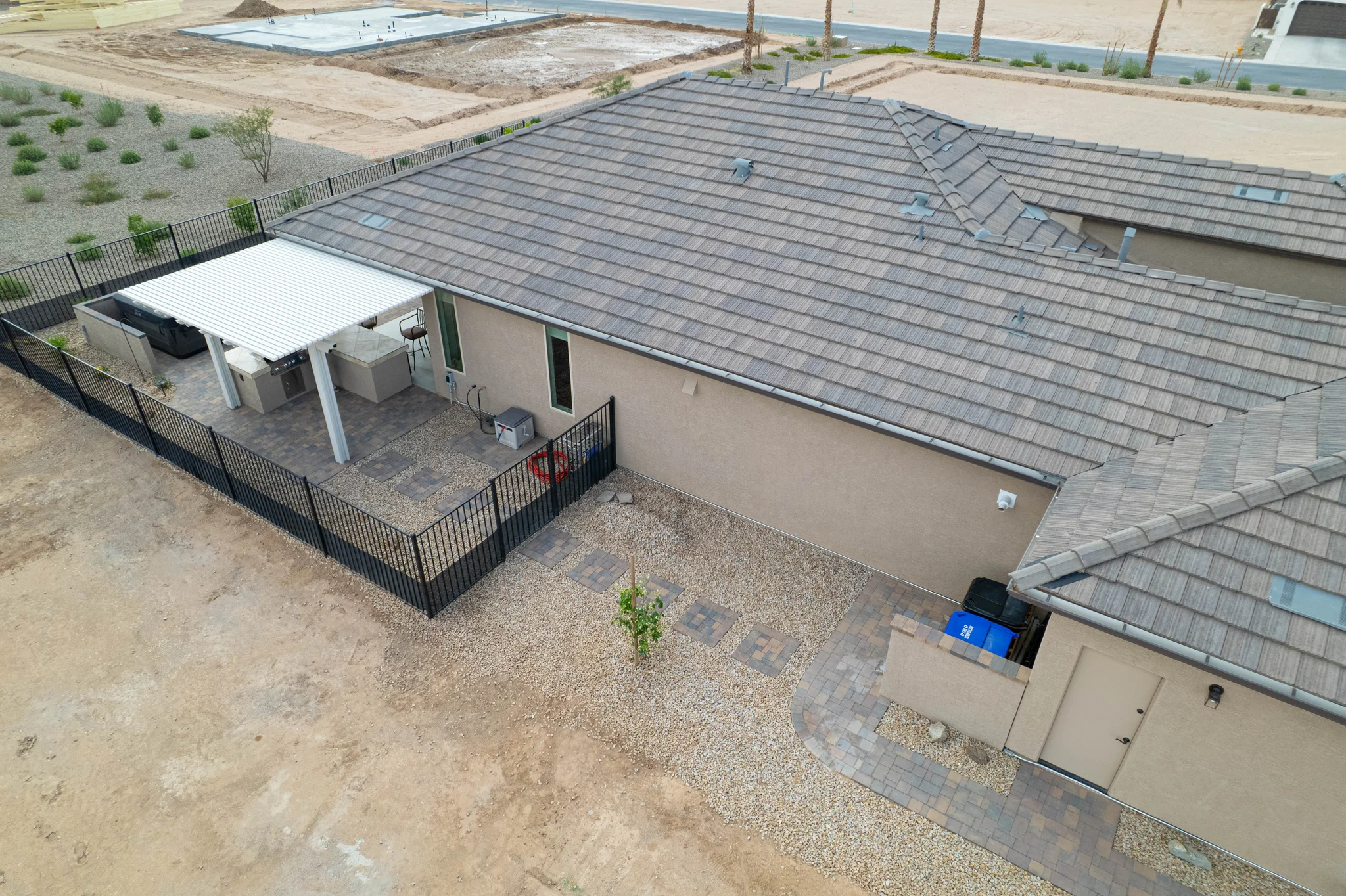 Aerial view of fenced backyard patio with pergola