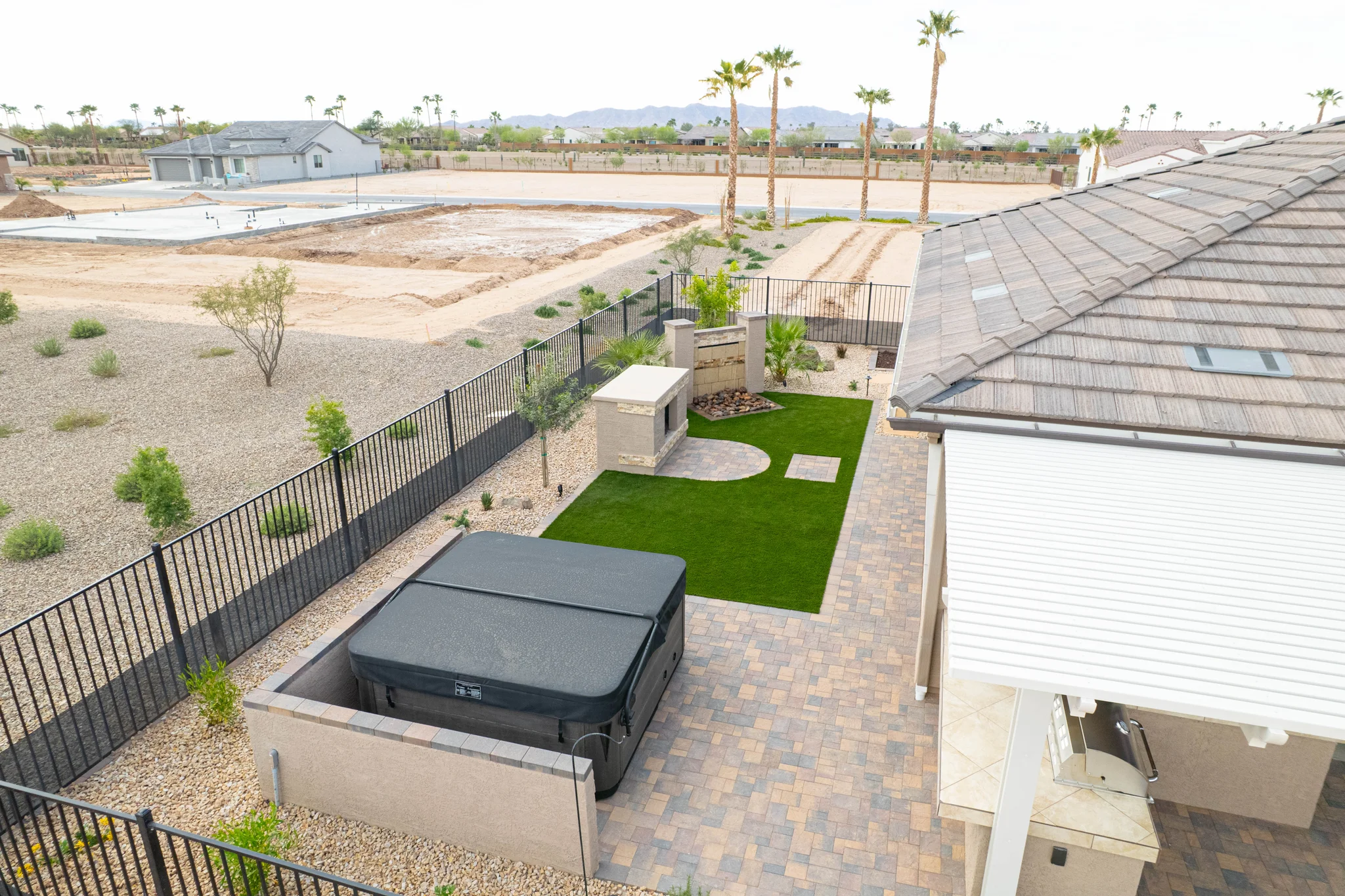 Modern desert backyard with spa, turf, and mountain views