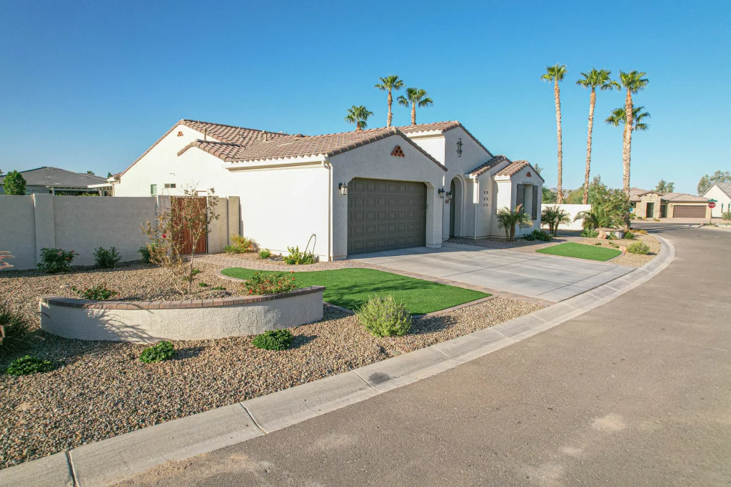 White stucco suburban home with palm trees and desert landscaping