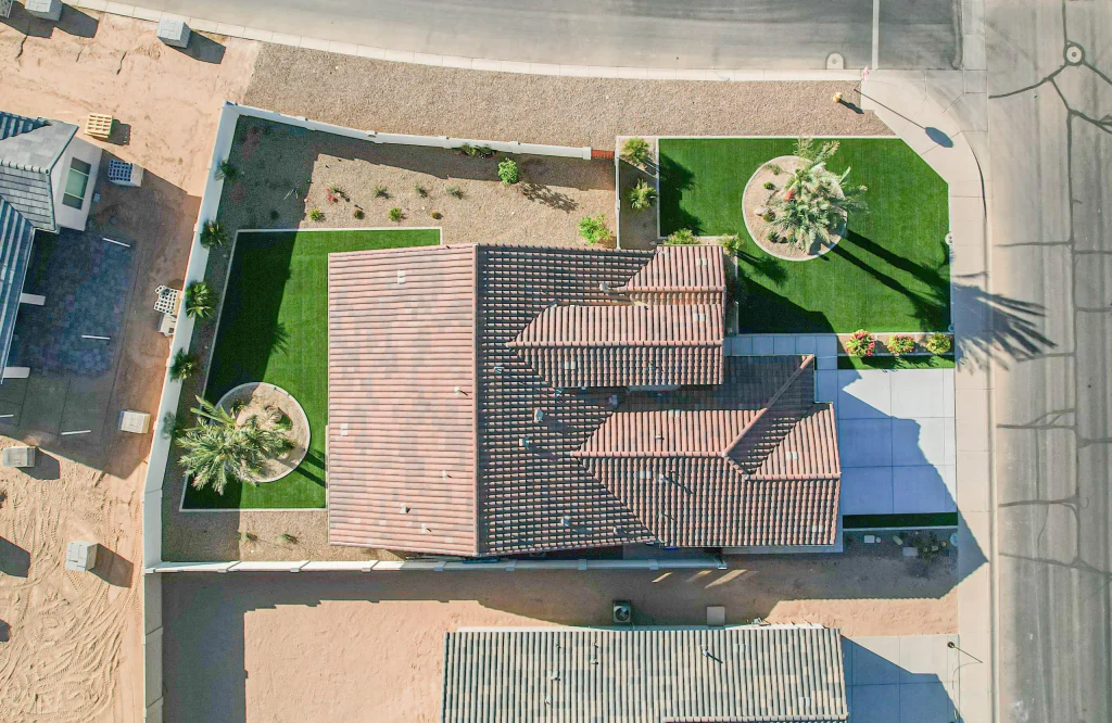 Aerial view of tiled-roof home with landscaped yard