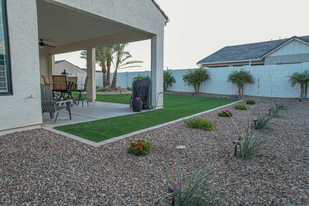 Covered patio overlooking landscaped backyard with palms and gravel beds.
