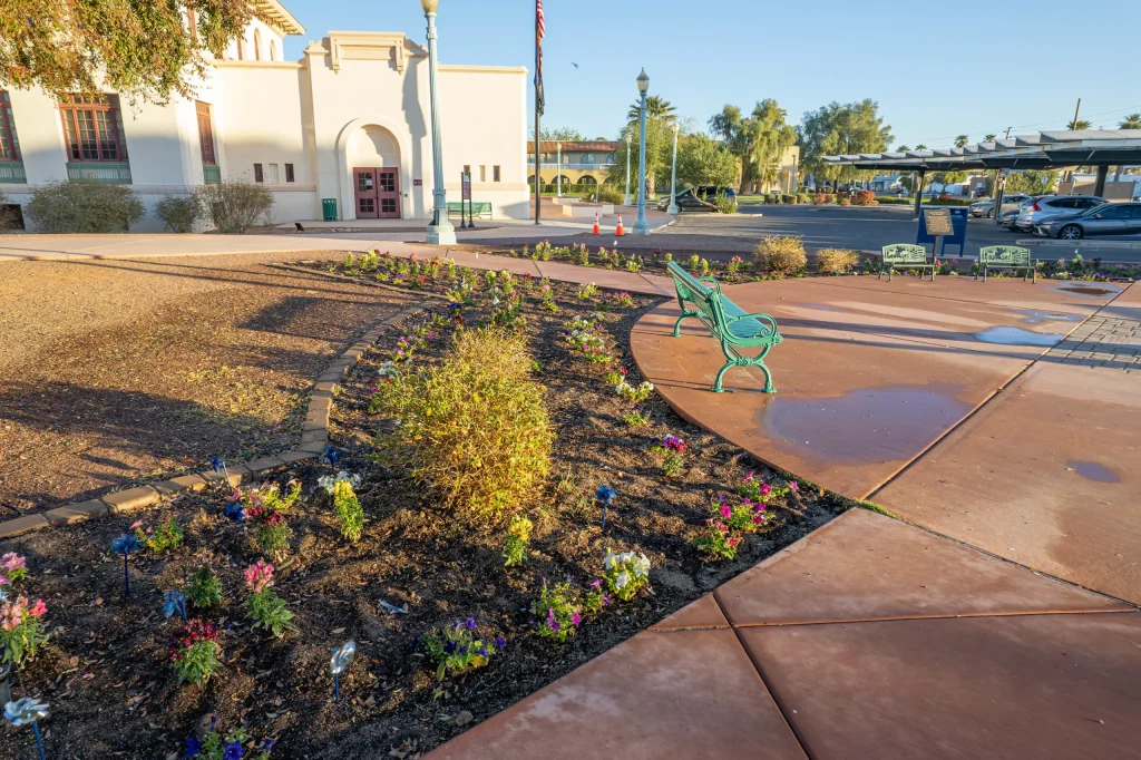 Flower beds and green benches outside a historic building