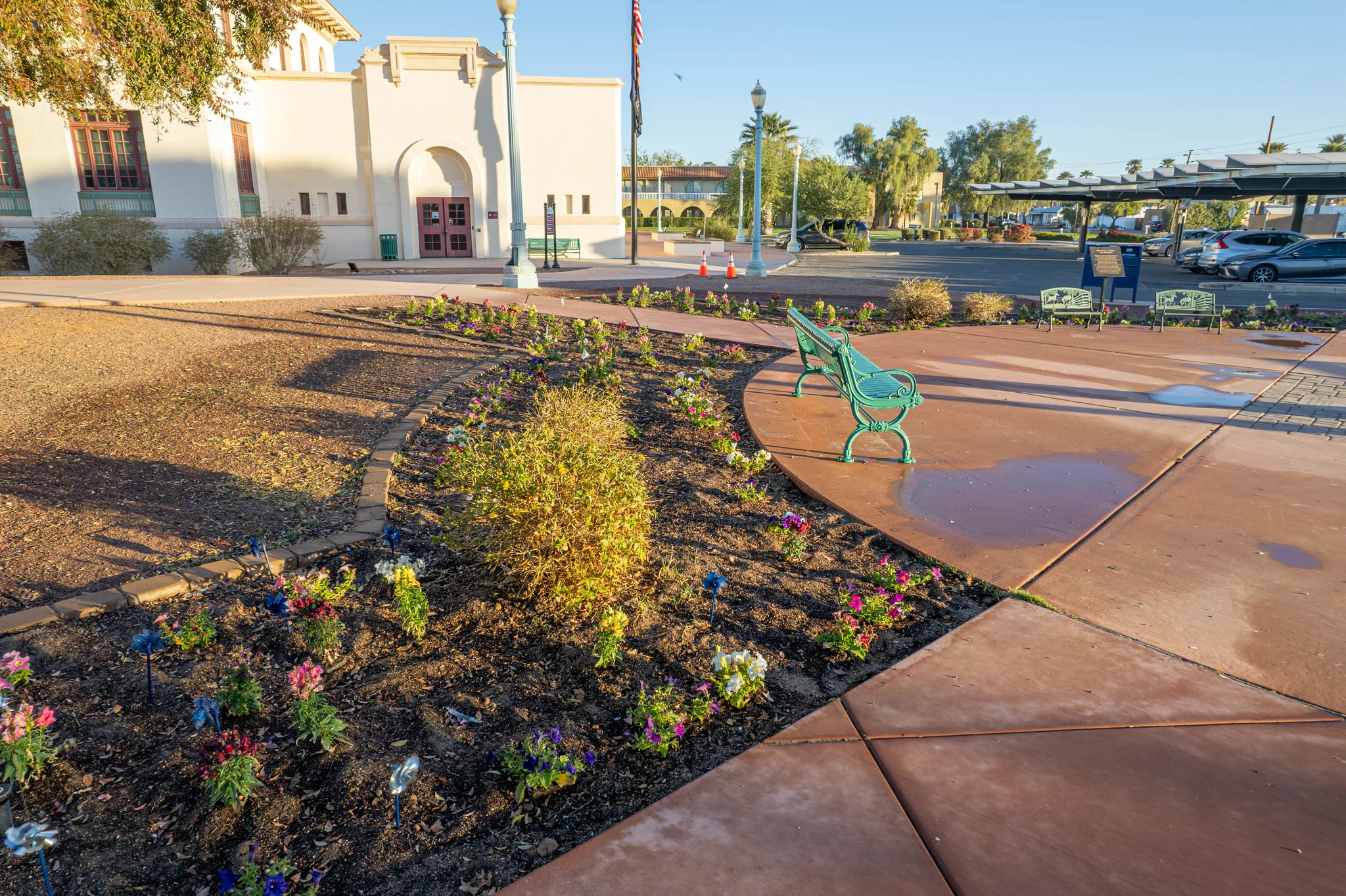 Flower garden and green benches outside historic civic building