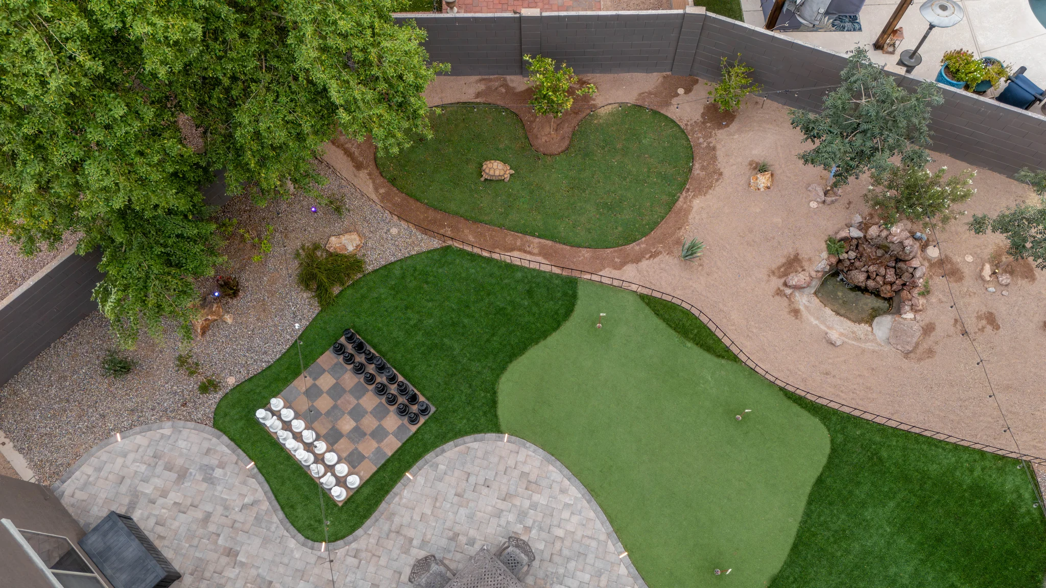 Aerial view of landscaped backyard with putting green and chessboard