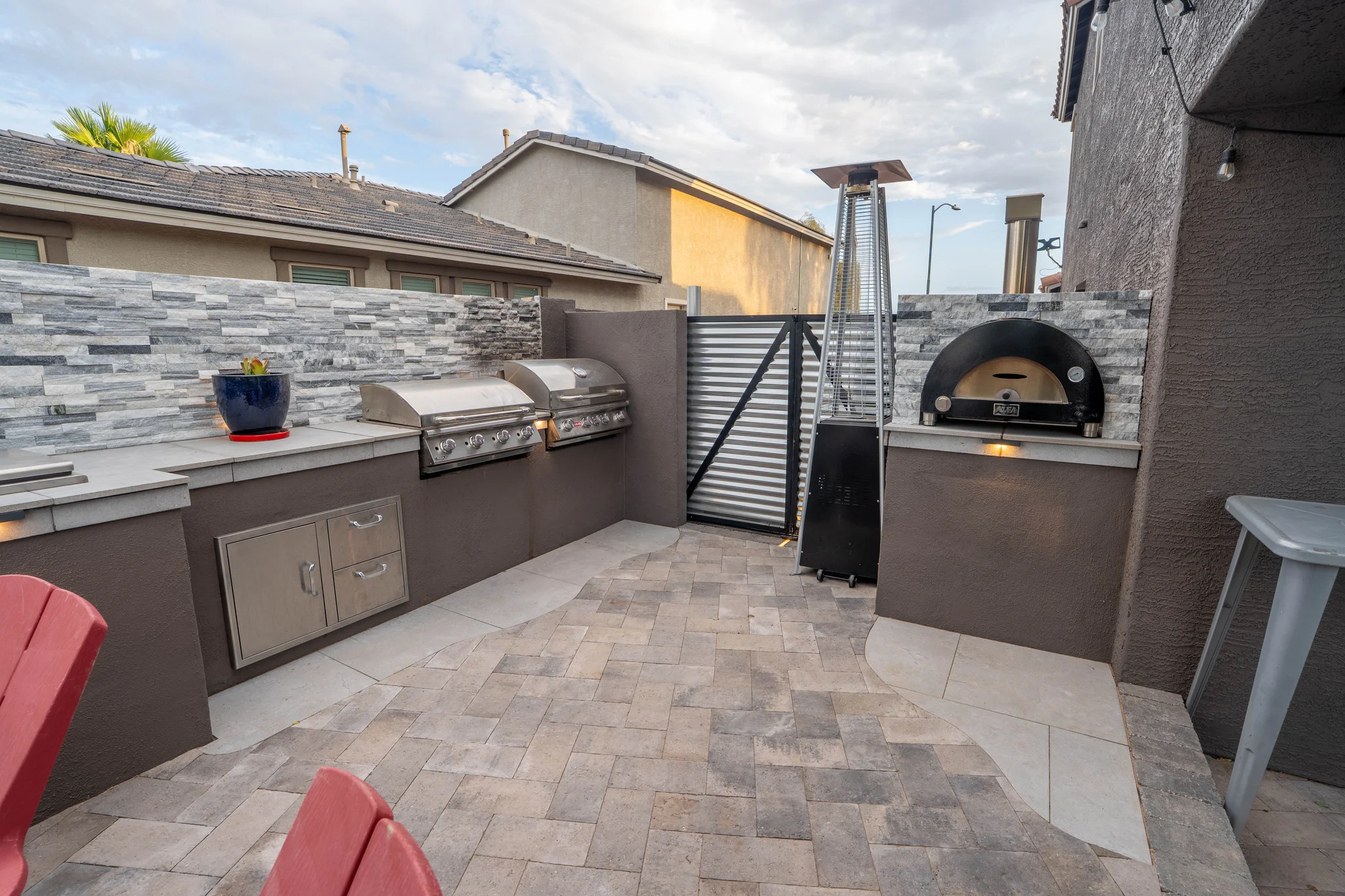 Outdoor kitchen with grills, pizza oven, and patio heater