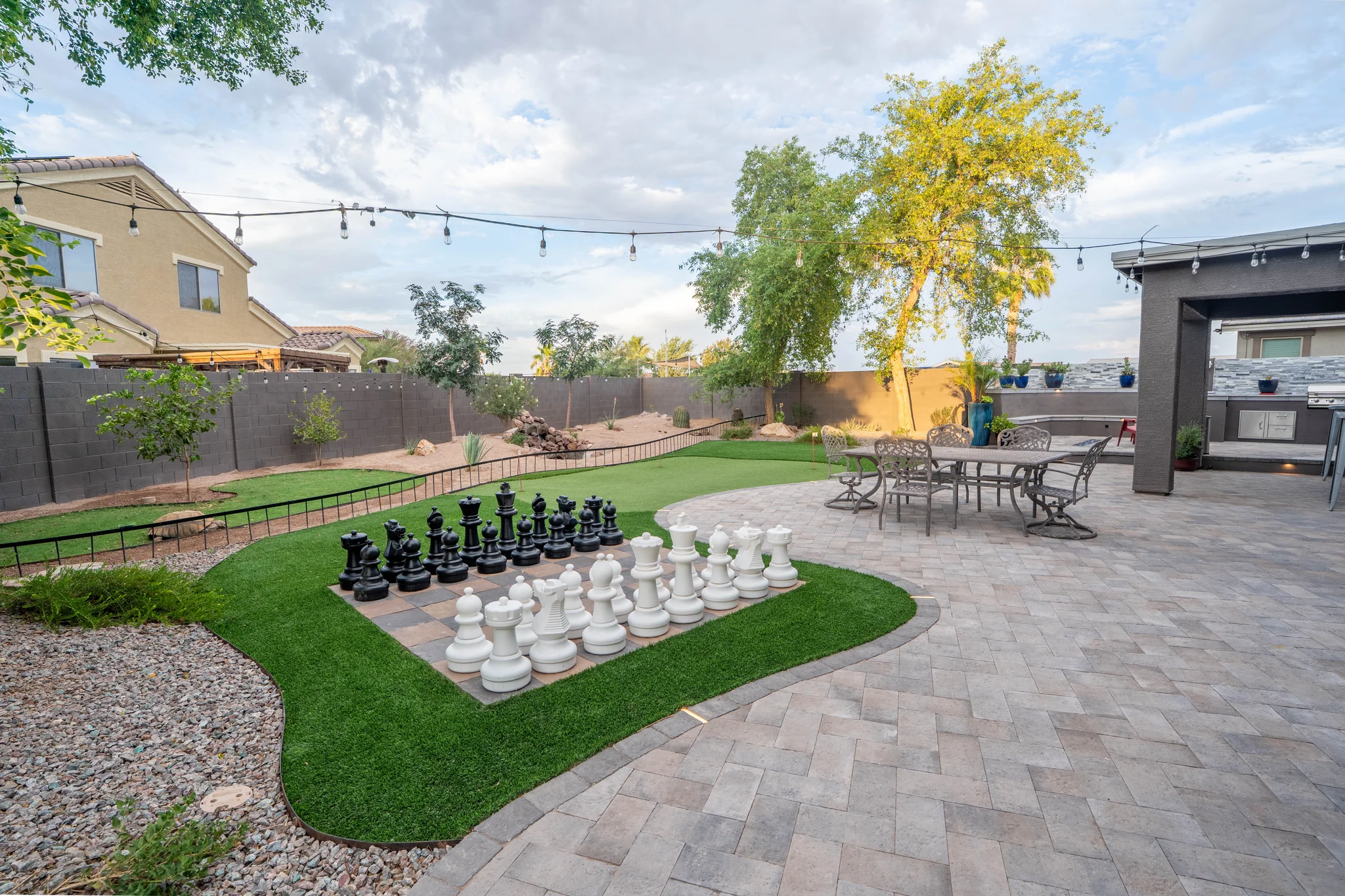 Backyard patio with giant chess set and outdoor kitchen