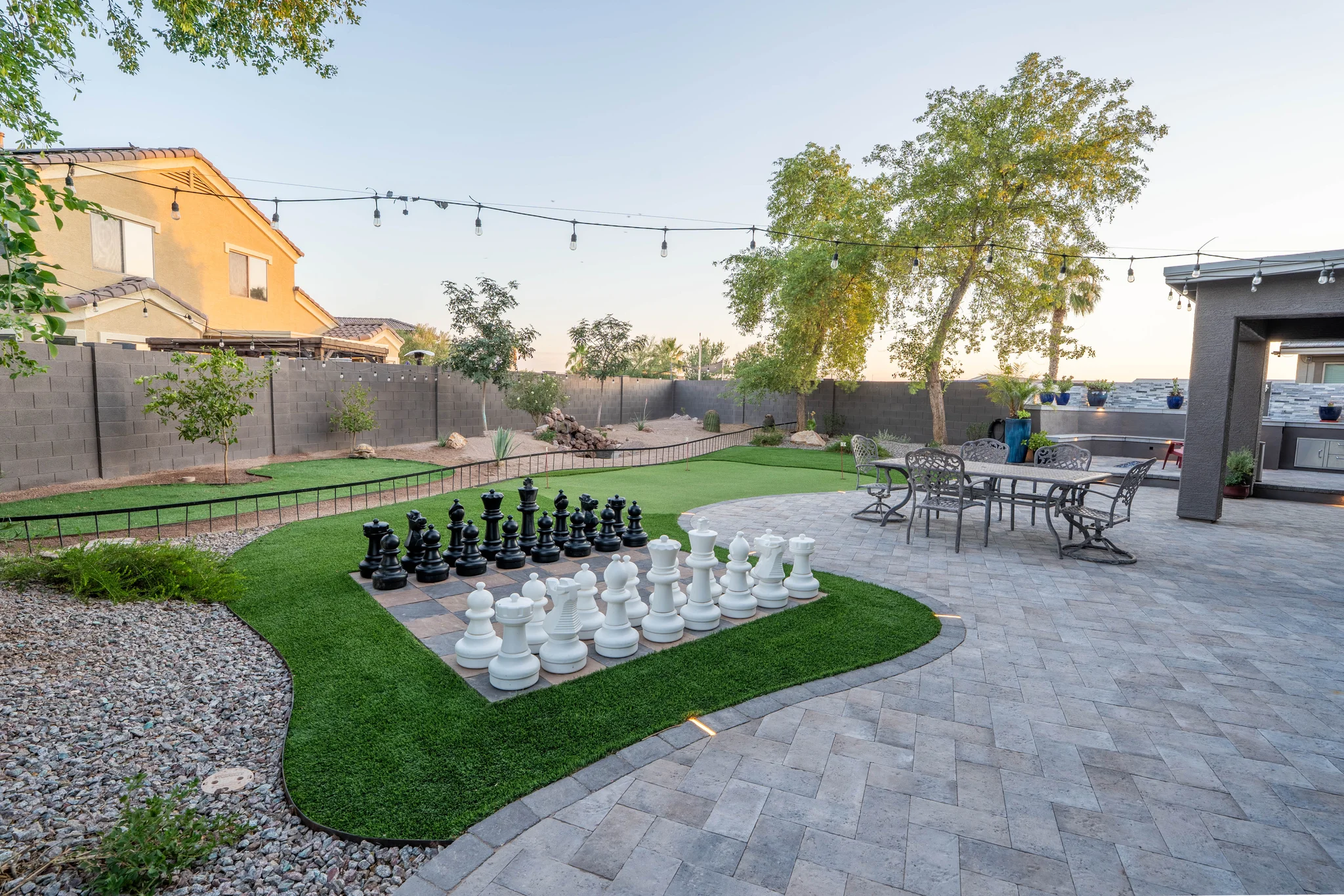 Backyard patio with giant chess set and string lights