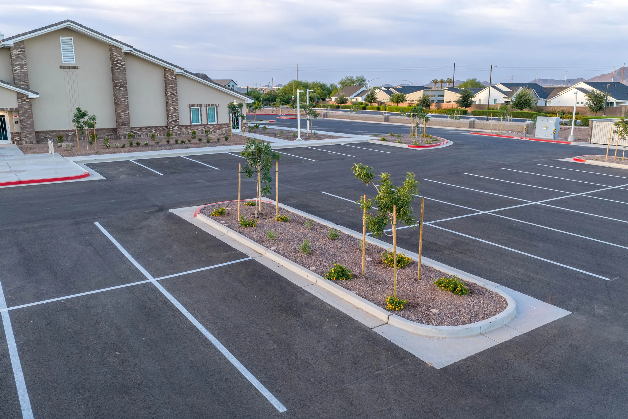 Empty landscaped parking lot beside suburban building