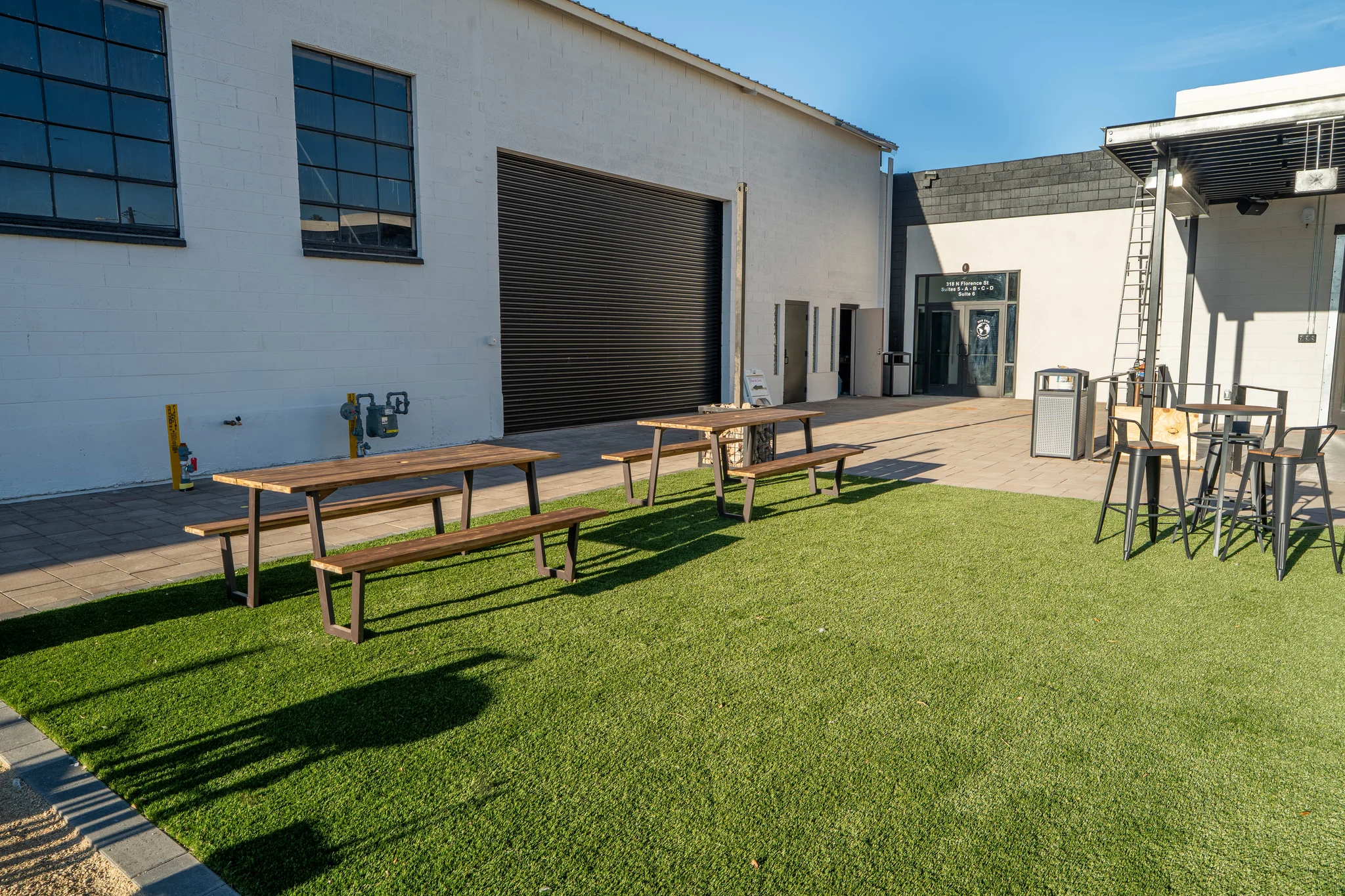 Outdoor patio with picnic tables beside industrial building