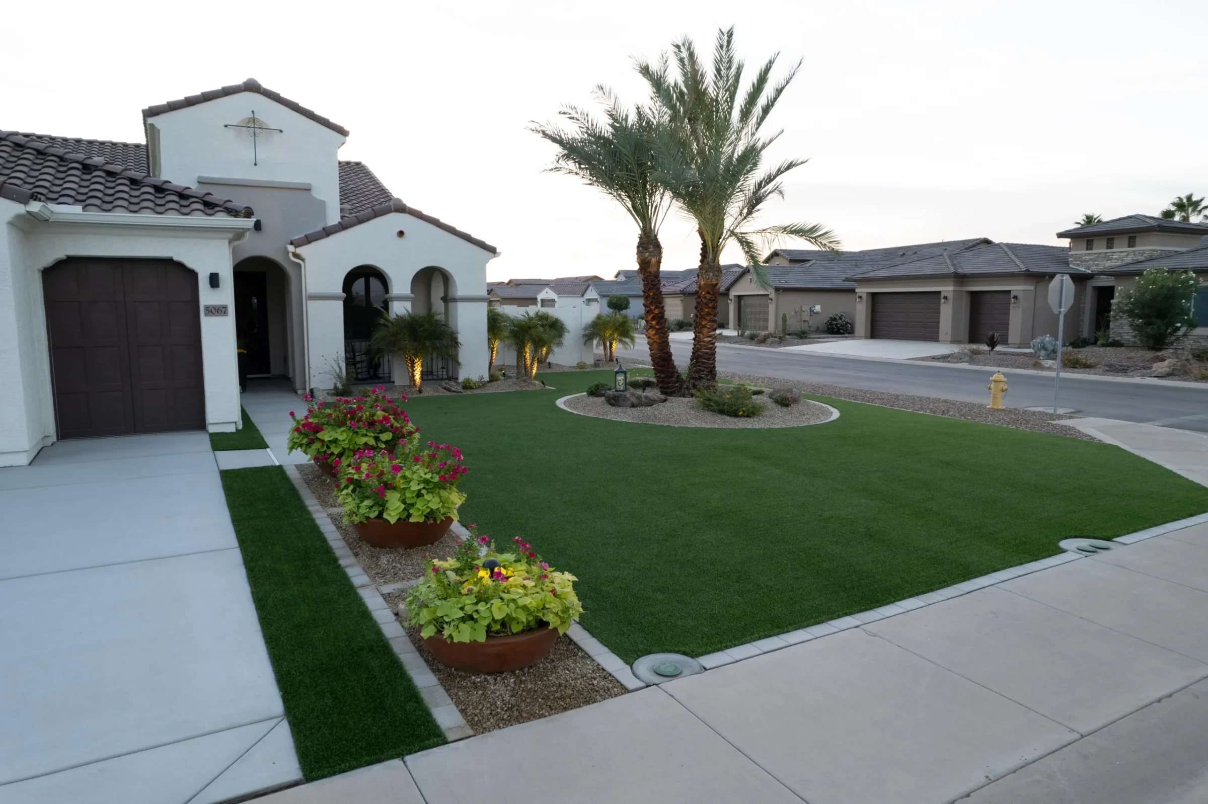 Mediterranean-style home with palm trees and manicured front lawn