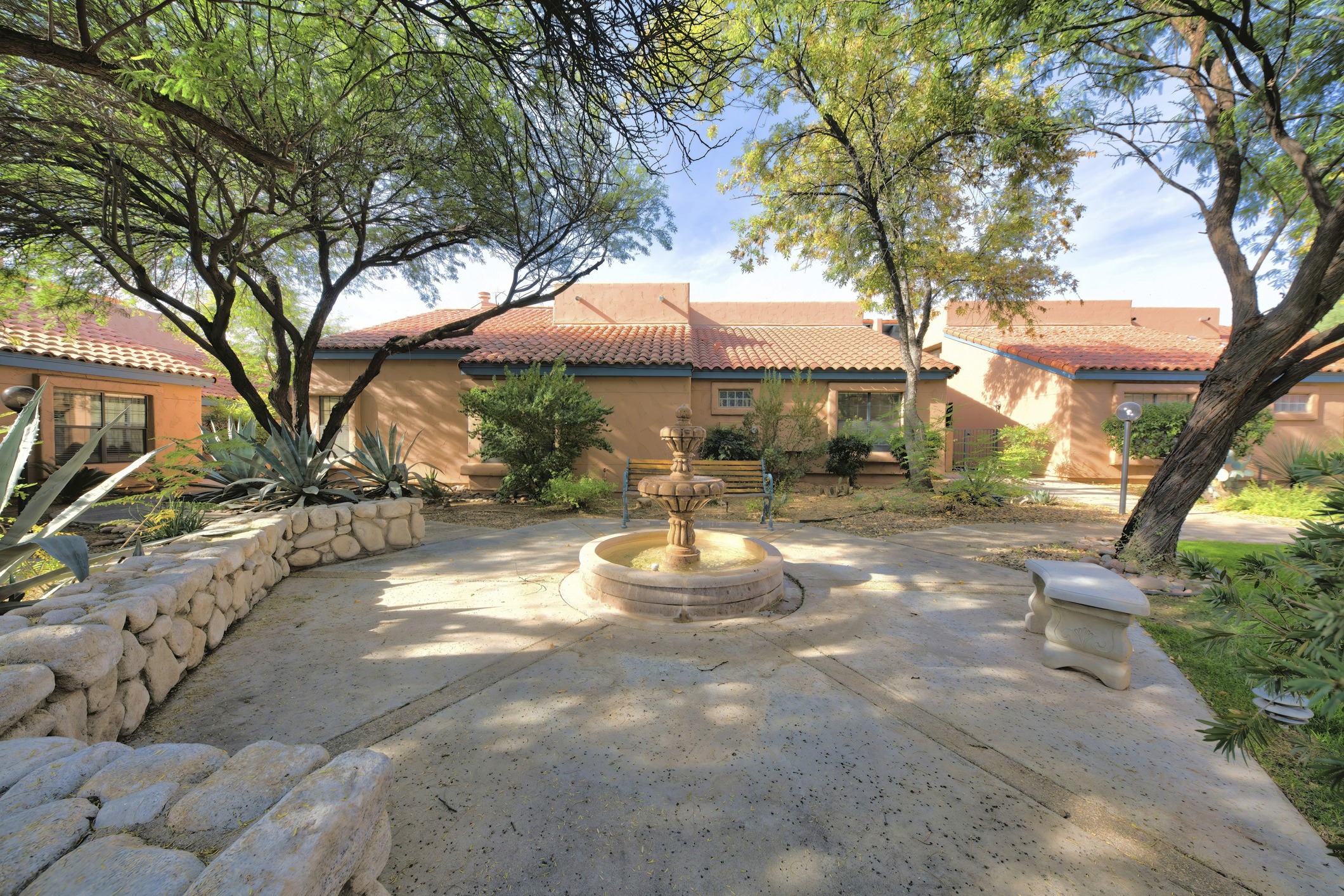 Shaded courtyard fountain outside a Spanish-style stucco home