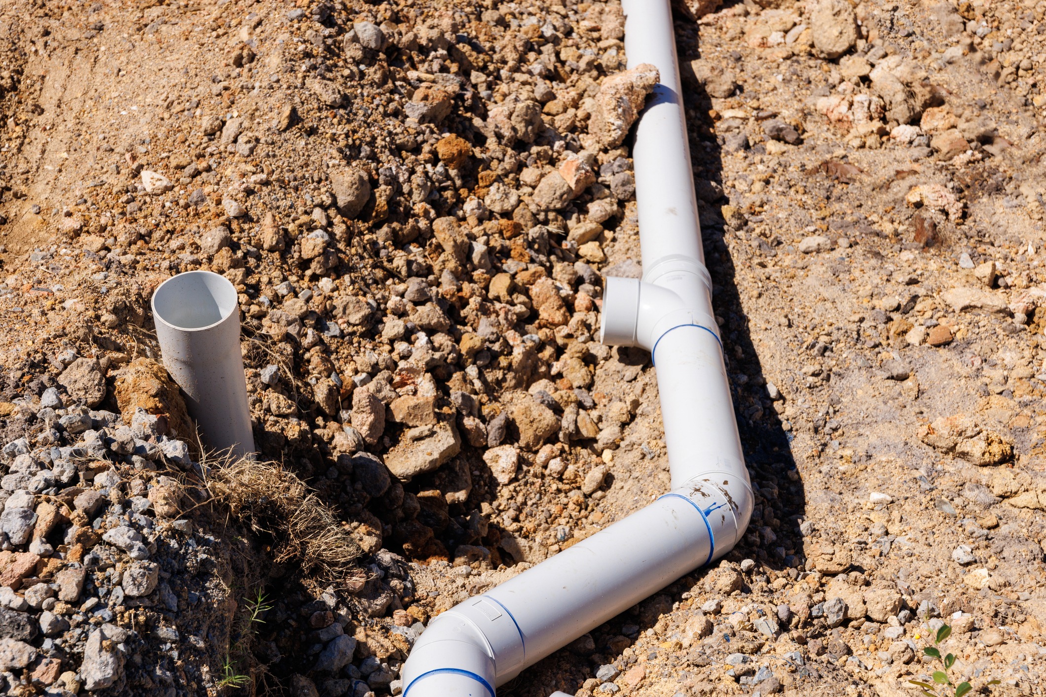 PVC drainage pipes installed in a dirt trench