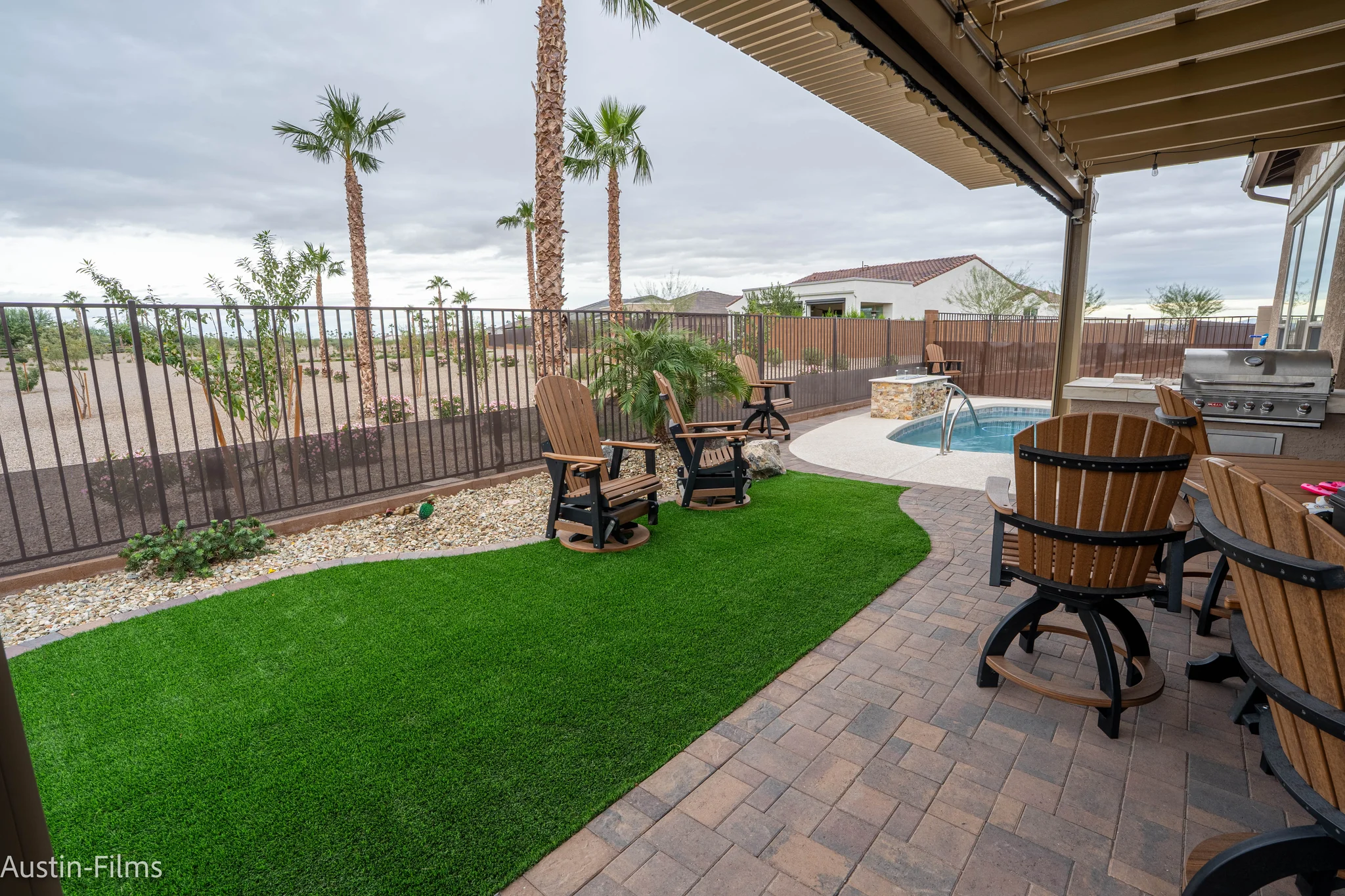 Covered patio with pool, grill, and palm trees