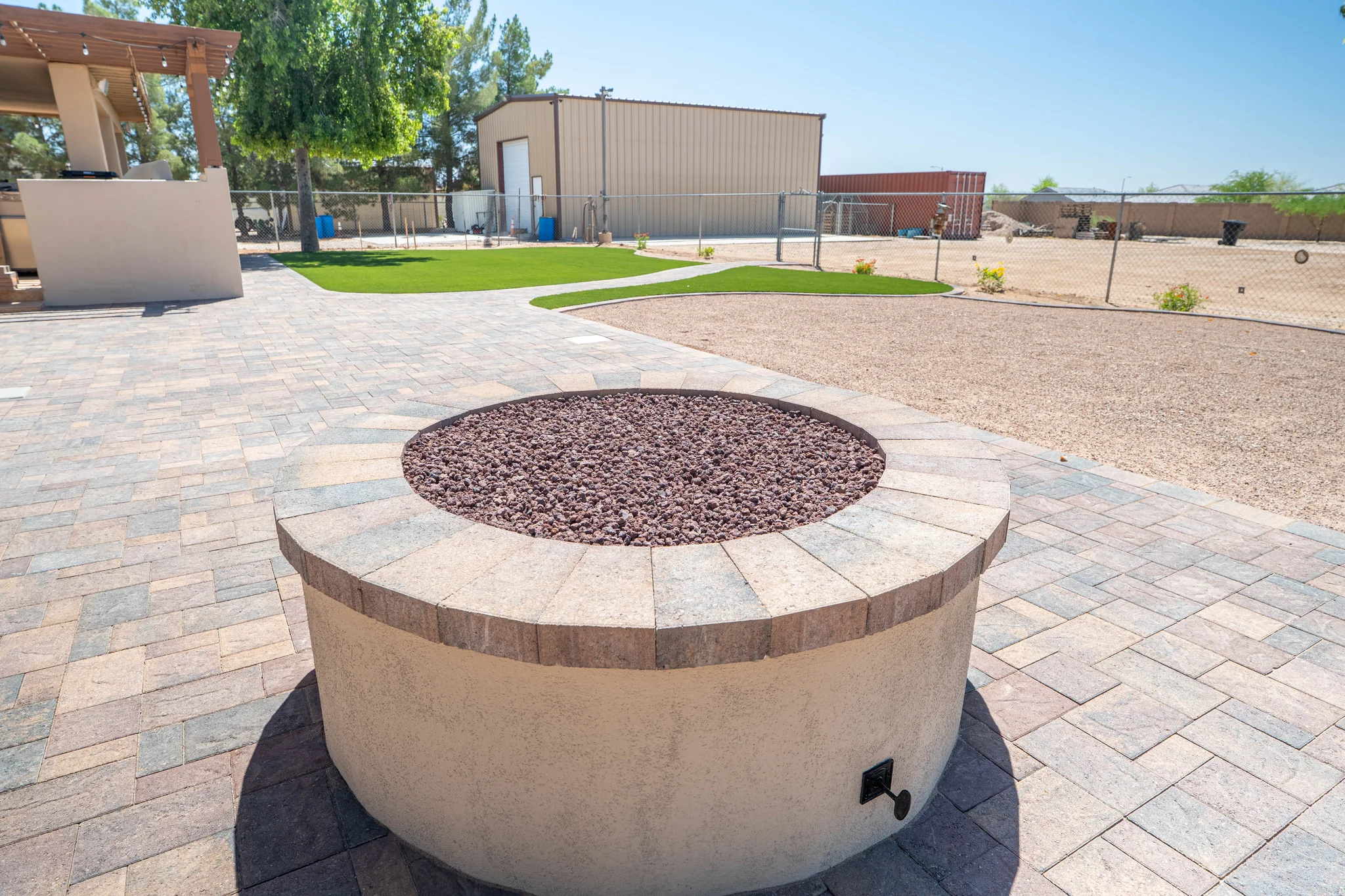 Circular fire pit on a paved backyard patio