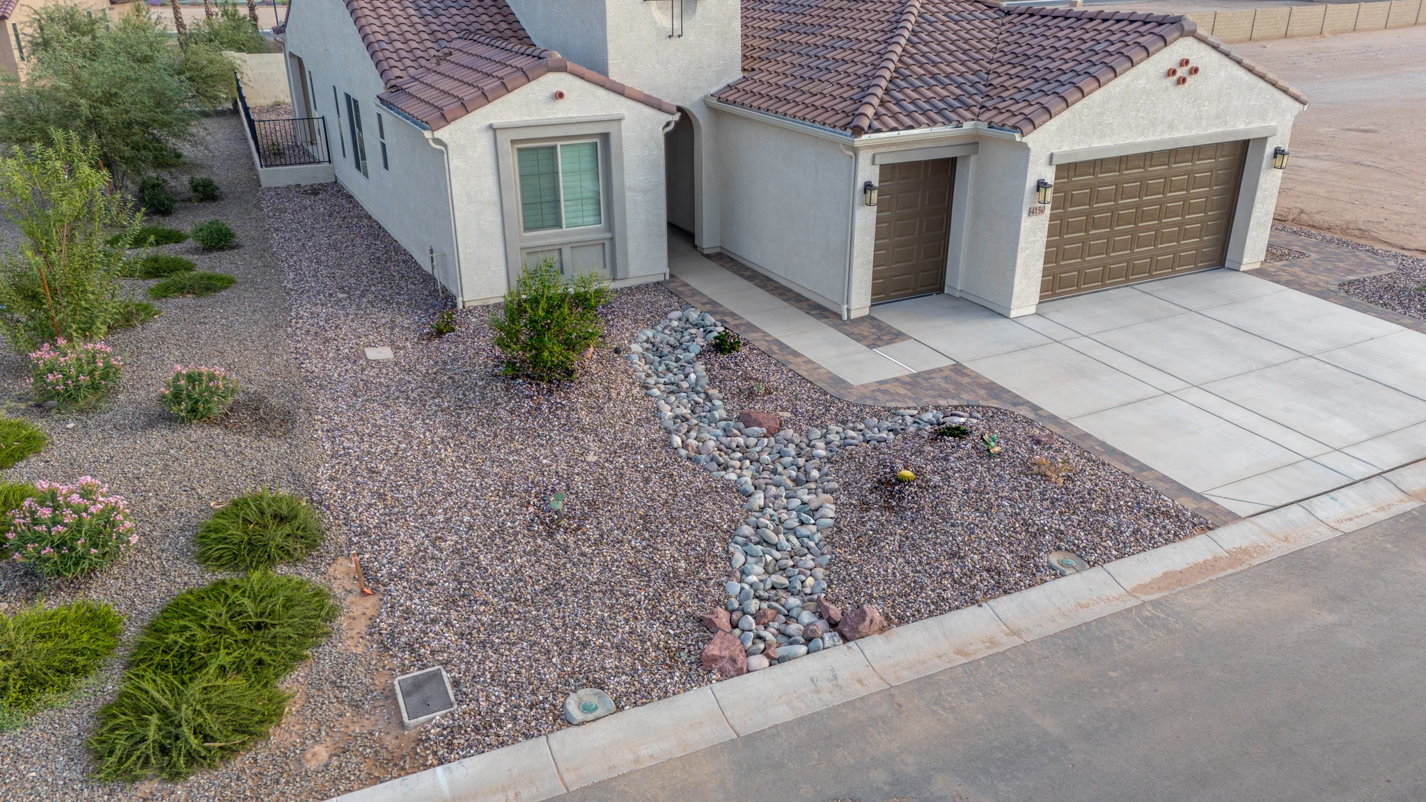 Desert-landscaped stucco home with three-car garage