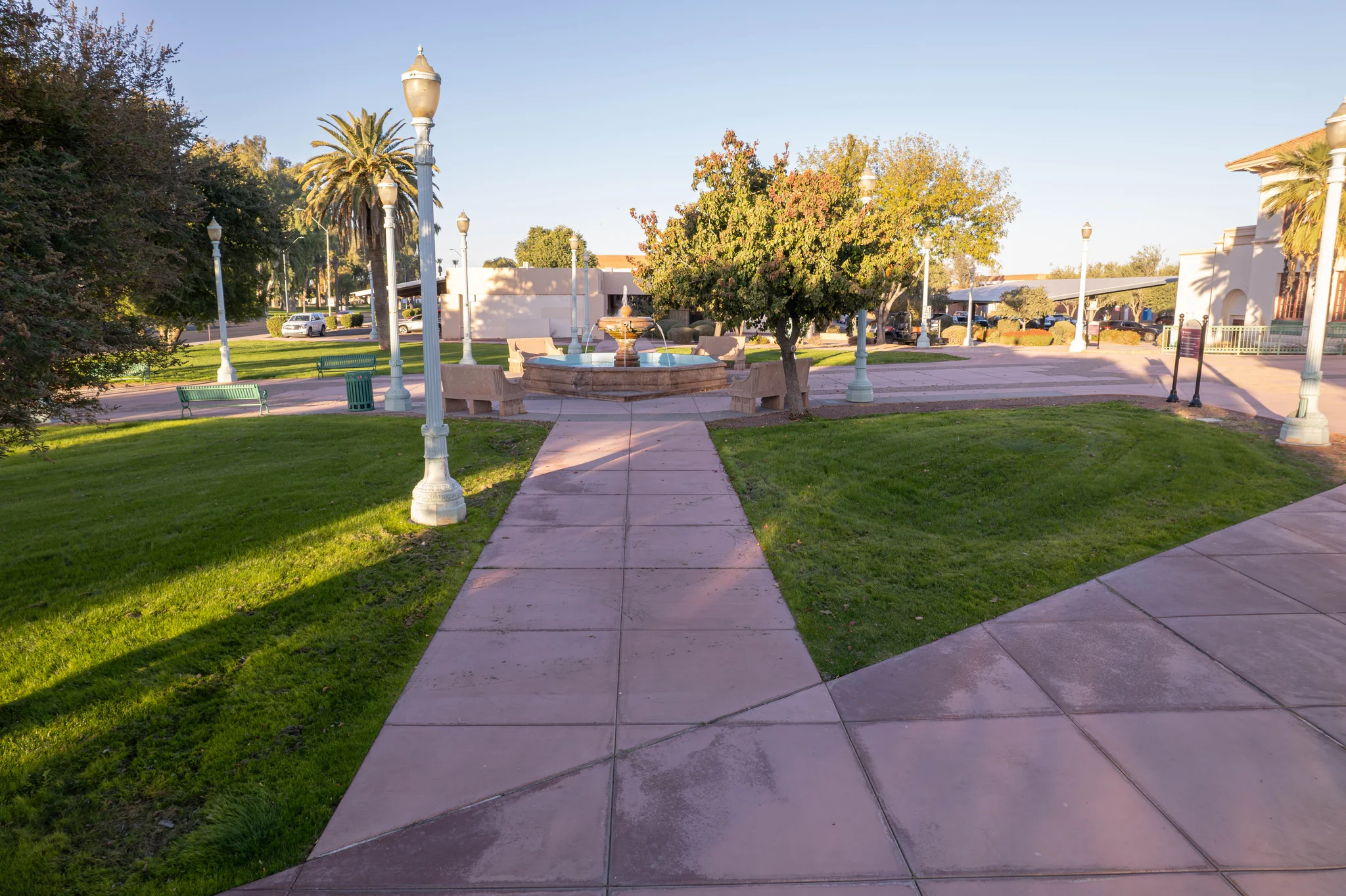 Tree-lined park walkway leading to a central fountain